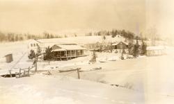 1947:  Framework of new Martin cottage with school house in back.