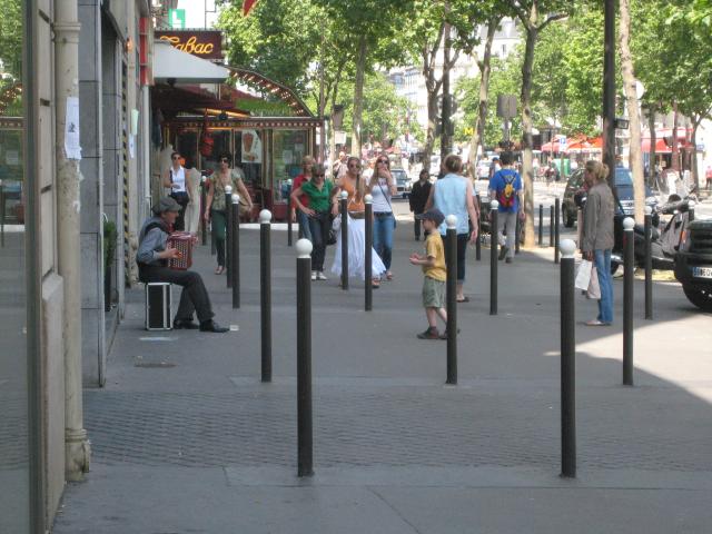 A sidewalk musician entertaining Justin with traditional French melodies.