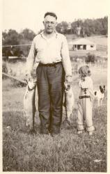 1938:  Chalie Passea and little Nancy. Mrs. Knight's cabin and Boots the dog in back.