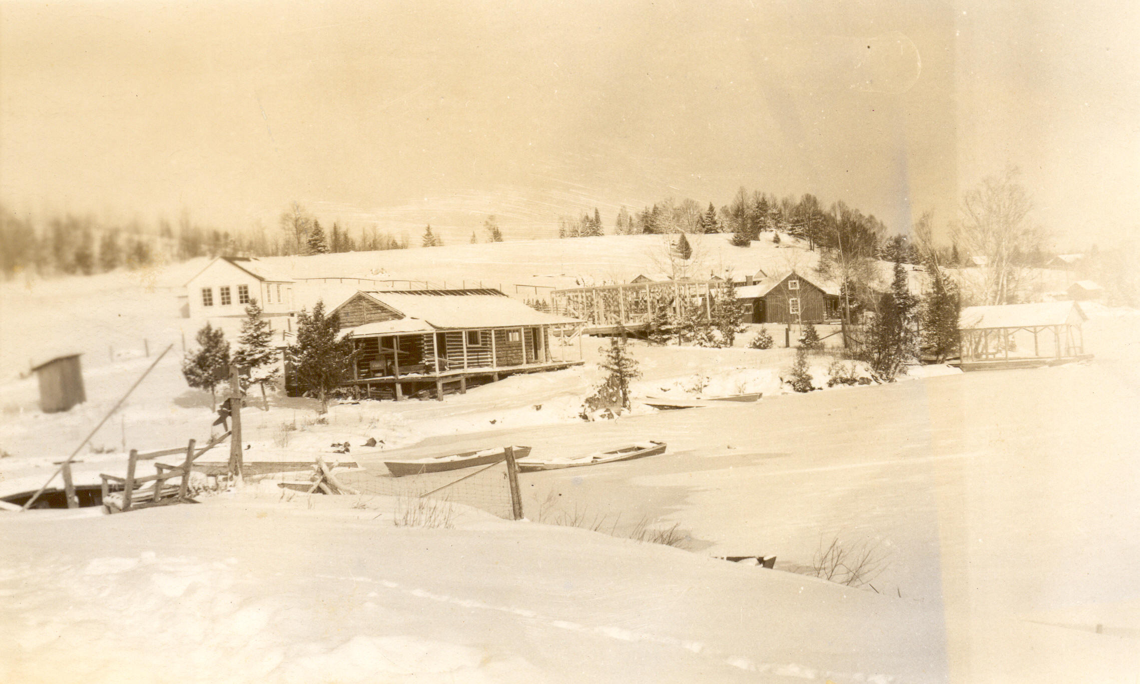 1947:  Framework of new Martin cottage with school house in back.
